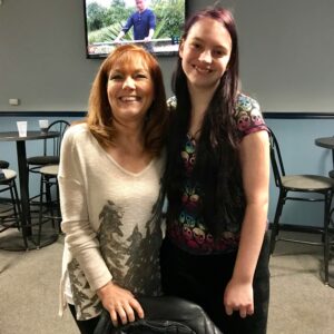 Two women smiling at the camera and posing for a picture.