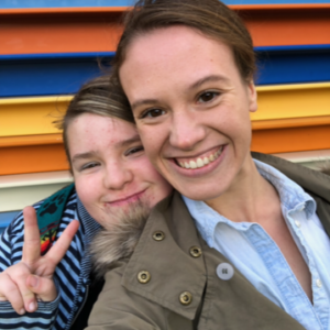 A young girl and her adult match smiling at the camera.