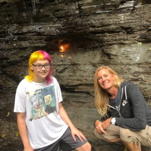 A match standing in front of a large rock.