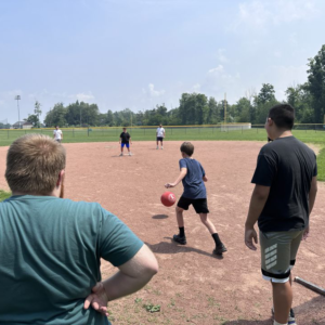 A group of people playing kickball.