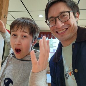 A young boy making a silly face with his adult match.